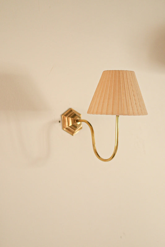 Brass curved sconce with velvet lampshade.